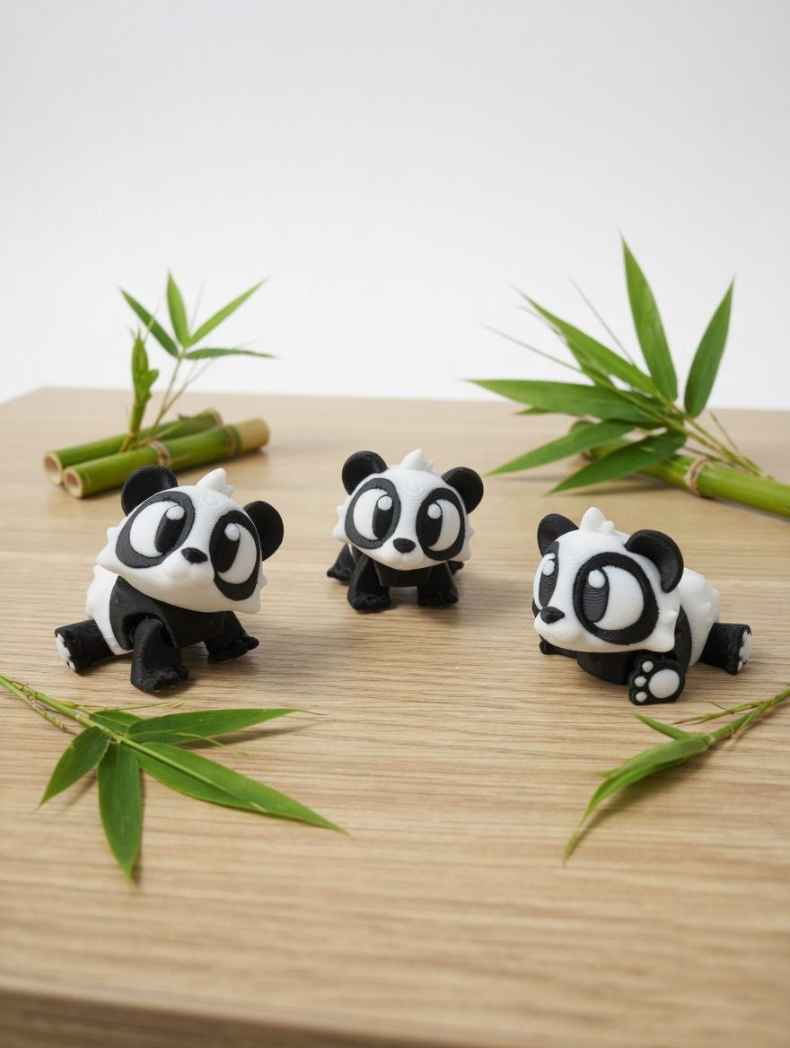 Three panda-shaped desk accessories on a wooden surface with bamboo leaves.